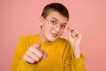 Image showing Caucasian girl\'s portrait isolated on coral pink studio background with copyspace