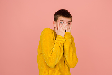 Image showing Caucasian girl\'s portrait isolated on coral pink studio background with copyspace