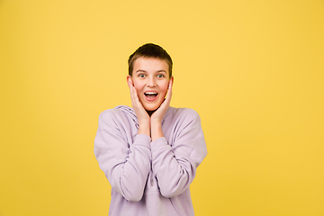 Image showing Caucasian girl\'s portrait isolated on yellow studio background with copyspace