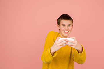 Image showing Caucasian girl\'s portrait isolated on coral pink studio background with copyspace