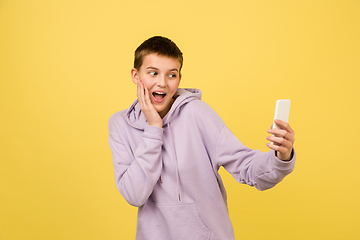 Image showing Caucasian girl\'s portrait isolated on yellow studio background with copyspace