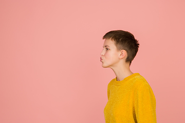 Image showing Caucasian girl\'s portrait isolated on coral pink studio background with copyspace