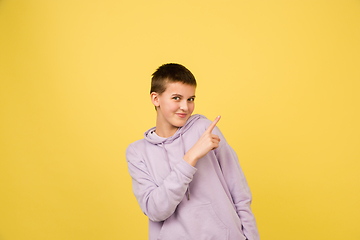 Image showing Caucasian girl\'s portrait isolated on yellow studio background with copyspace