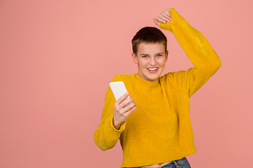 Image showing Caucasian girl\'s portrait isolated on coral pink studio background with copyspace