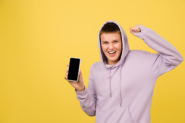 Image showing Caucasian girl\'s portrait isolated on yellow studio background with copyspace