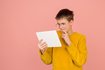 Image showing Caucasian girl\'s portrait isolated on coral pink studio background with copyspace