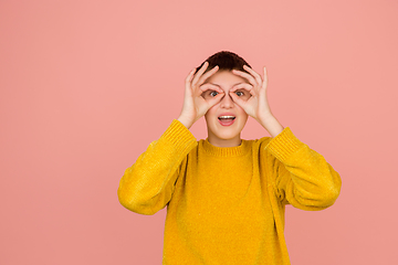 Image showing Caucasian girl\'s portrait isolated on coral pink studio background with copyspace