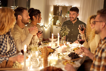 Image showing happy friends drinking red wine at christmas party