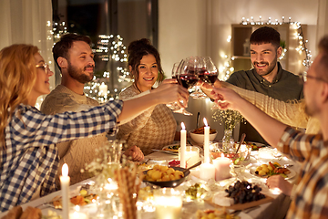 Image showing happy friends drinking red wine at christmas party