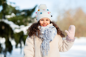 Image showing happy little girl waving hand outdoors in winter