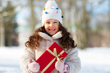 Image showing happy girl with red christmas gift in winter park