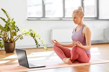 Image showing woman with laptop in lotus pose at yoga studio