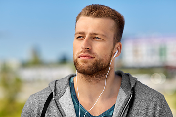 Image showing man in earphones listening to music outdoors