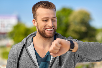 Image showing happy man with fitness tracker in city