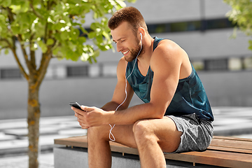 Image showing young athlete man with earphones and smartphone