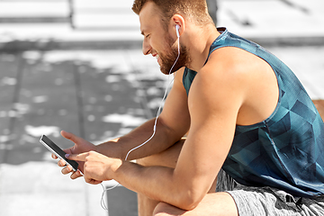 Image showing young athlete man with earphones and smartphone