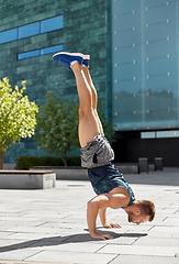 Image showing young man exercising and doing handstand outdoors