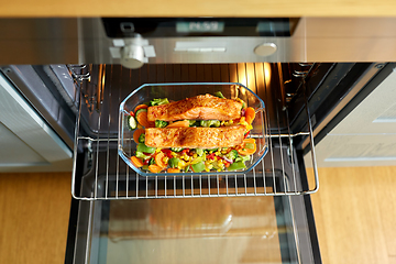 Image showing food cooking in baking dish in oven at home