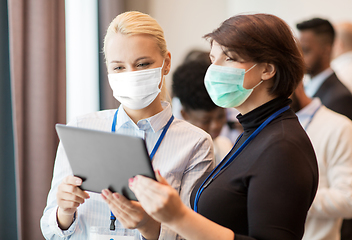 Image showing business people in masks with tablet computer