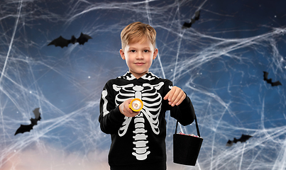 Image showing boy with candies and flashlight on halloween