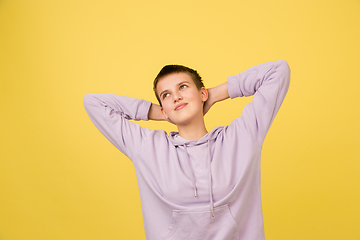 Image showing Caucasian girl\'s portrait isolated on yellow studio background with copyspace