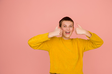 Image showing Caucasian girl\'s portrait isolated on coral pink studio background with copyspace