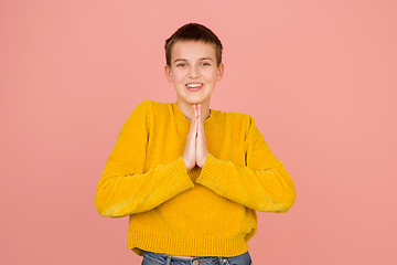 Image showing Caucasian girl\'s portrait isolated on coral pink studio background with copyspace