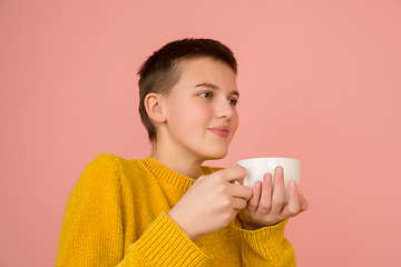 Image showing Caucasian girl\'s portrait isolated on coral pink studio background with copyspace