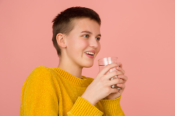 Image showing Caucasian girl\'s portrait isolated on coral pink studio background with copyspace