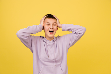 Image showing Caucasian girl\'s portrait isolated on yellow studio background with copyspace