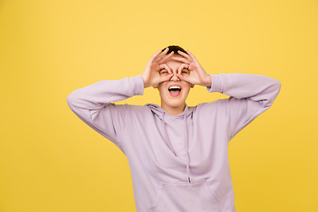 Image showing Caucasian girl\'s portrait isolated on yellow studio background with copyspace