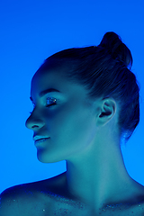 Image showing Handsome woman\'s portrait isolated on blue studio background in neon light, monochrome
