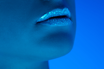 Image showing Handsome woman\'s close up portrait isolated on blue studio background in neon light, monochrome