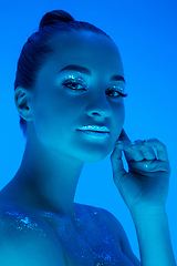 Image showing Handsome woman\'s portrait isolated on blue studio background in neon light, monochrome