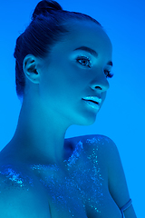 Image showing Handsome woman\'s portrait isolated on blue studio background in neon light, monochrome