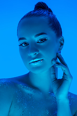 Image showing Handsome woman\'s portrait isolated on blue studio background in neon light, monochrome