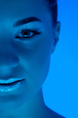 Image showing Handsome woman\'s portrait isolated on blue studio background in neon light, monochrome