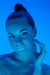 Image showing Handsome woman\'s portrait isolated on blue studio background in neon light, monochrome