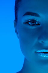 Image showing Handsome woman\'s portrait isolated on blue studio background in neon light, monochrome