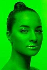 Image showing Handsome woman\'s portrait isolated on green studio background in neon light, monochrome