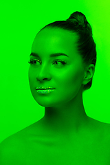 Image showing Handsome woman\'s portrait isolated on green studio background in neon light, monochrome