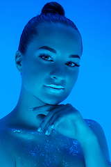 Image showing Handsome woman\'s portrait isolated on blue studio background in neon light, monochrome