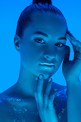 Image showing Handsome woman\'s portrait isolated on blue studio background in neon light, monochrome