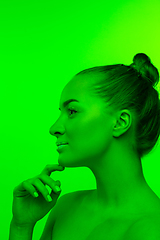 Image showing Handsome woman\'s portrait isolated on green studio background in neon light, monochrome