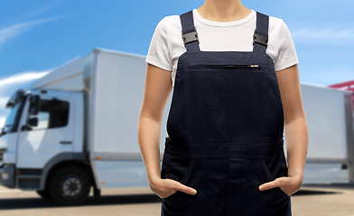 Image showing close up of female worker in overall over truck