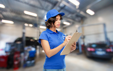 Image showing female worker with clipboard at car service