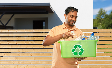 Image showing smiling young indian man sorting plastic waste