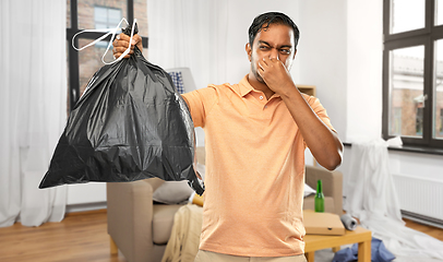 Image showing indian man holding stinky trash bag