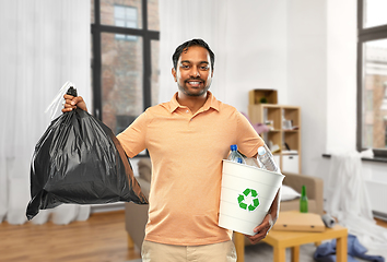 Image showing smiling indian man sorting paper and plastic waste