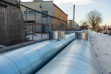 Image showing outdoor pipeline and old hangar in winter